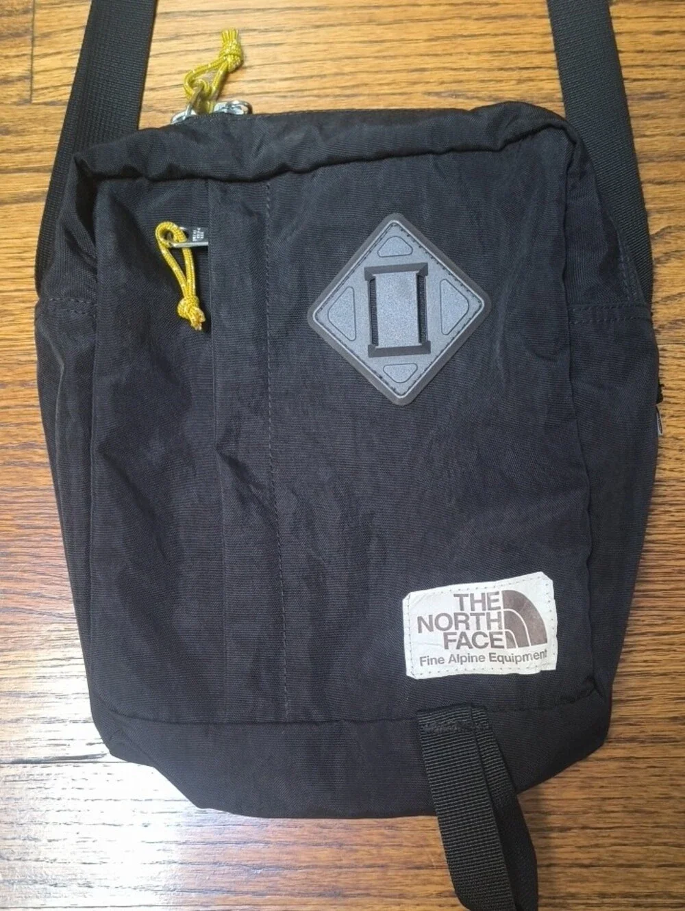 The North Face Black Crossbody Pack with Yellow Cord Pulls
